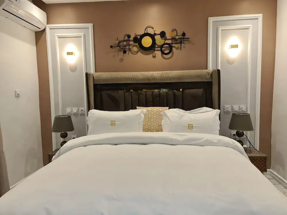 Chambre avec tête de lit et literie blanche